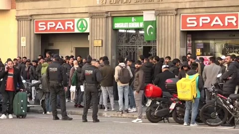 Pakistanis queue outside Barcelona consulate after mass migrant regularization a Stock Footage 327858664