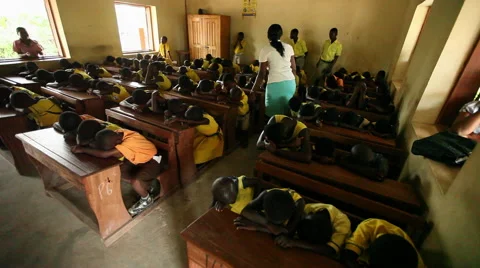 PAKRO CLASSROOM: WIDE OF STUDENTS WITH HEADS DOWN ON DESKS Stock Footage 59734920