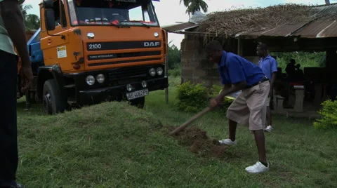 PAKRO STUDENT USES PICK AX IN FRONT OF AN ORANGE TRUCK Stock Footage 58107391
