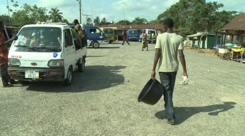 PAKRO YOUNG MAN CARRIES EMPTY WATER CONTAINER DOWN STREET Stock Footage 58930457