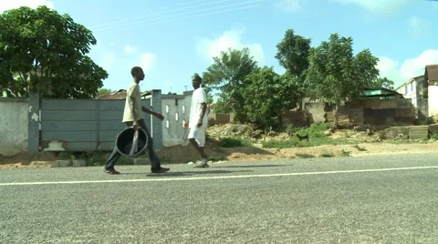 PAKRO YOUNG MAN WALKS DOWN STREET WITH EMPTY CONTAINER Stock Footage 58930625