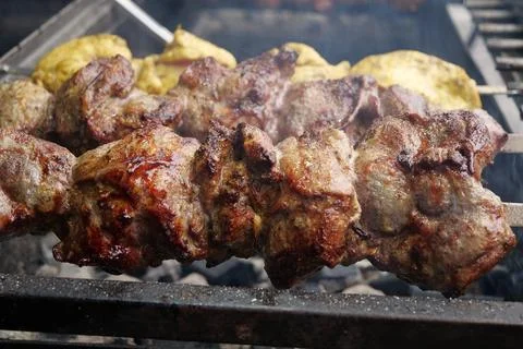 Palatable shish kebabs with different meats rotates on spits Fotos Stock