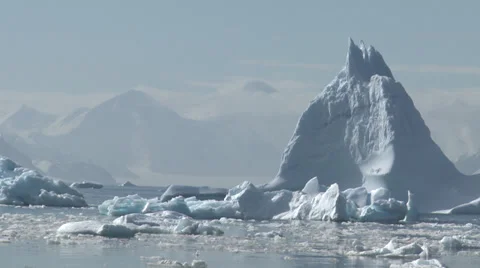 Pale blue bergs, sea ice, mountains, Antarctica Stock Footage