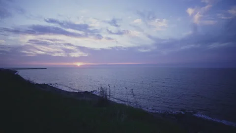 Pale cloudy violet sunset time lapse on saint-laurent river shore grass hill Stock Footage 275315329