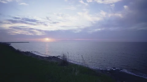 Pale cloudy violet sunset time lapse on saint-laurent river shore grass hill Vídeo Stock 275315339