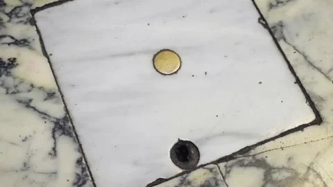 Pale marble panel with one round golden inlay and dark hole for draining water Видео 348421977