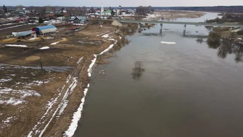 A pale river stream with gray water, the remains of snowdrifts on the shore. Stock Footage 225836038