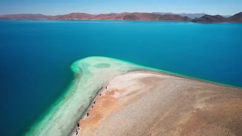 Pale sand spit and clear shallows in blue Yamdrok Lake Video stock 345886101