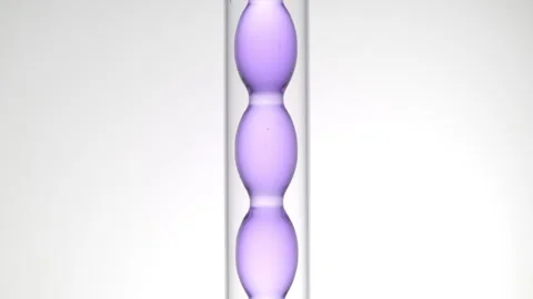 Pale violet liquid in bulb condenser on light grey background Stock Footage 339378112