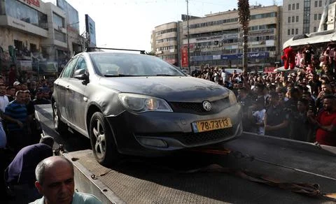 Palestinian security forces load onto a tow truck a vehicle belonging to I... Foto stock