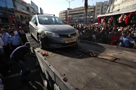 Palestinian security forces load onto a tow truck a vehicle belonging to I... Foto stock