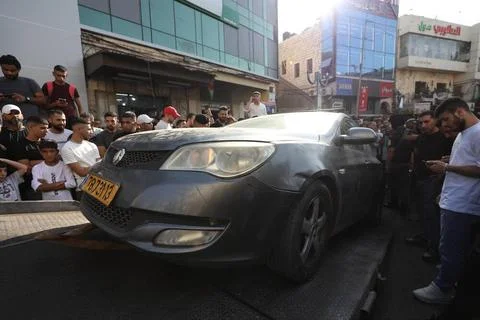 Palestinian security forces load onto a tow truck a vehicle belonging to I... Foto stock