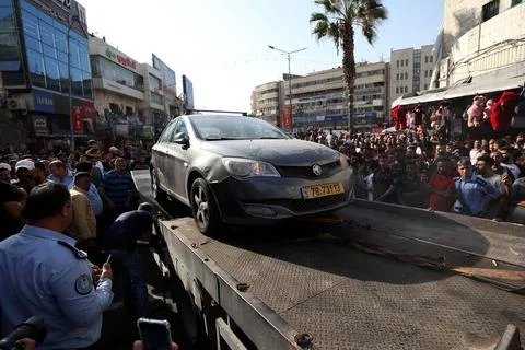Palestinian security forces load onto a tow truck a vehicle belonging to I... Foto stock