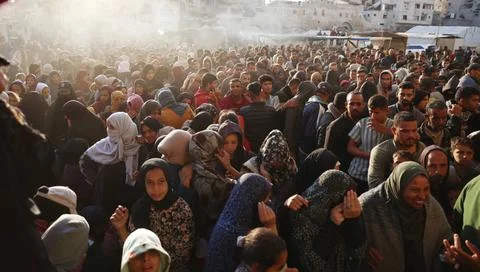  Palestinians wait in crowded queue for long hours to buy bread from the o... Foto stock