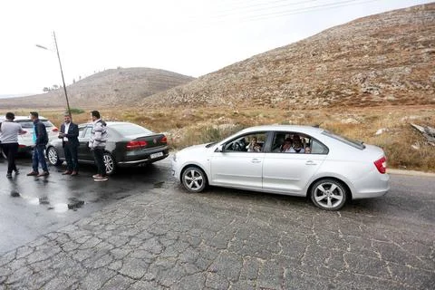 Palestinians wait in their vehicles wait in an hours-long queue at an Isr... Stock Photos