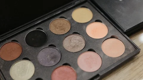 A palette with eye shadows and a makeup brush in. Close up of woman make up Stock Footage 129458649
