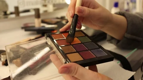 A palette with eye shadows and a makeup brush in slow motion. Close up of woman Video stock 190958457