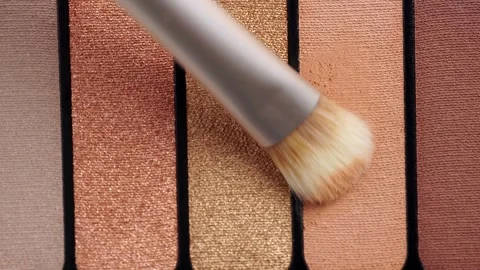A palette with eye shadows and a makeup brush. Brush gains beige eyeshadows.. Stock Footage 256783602