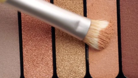A palette with eye shadows and a makeup brush. Brush gains beige eyeshadows.. Stock Footage 257422891