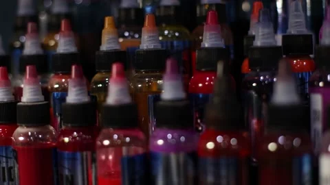 Palette of multicolour tattoo inks in small bottles. Selective focus, blurred. Stock Footage 168101222