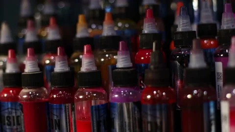 Palette of multicolour tattoo inks in small bottles. Selective focus, blurred. Video stock 168151694