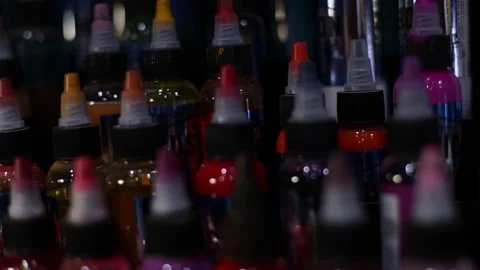Palette of multicolour tattoo inks in small bottles. Selective focus, blurred. Stock Footage 168632881