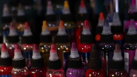 Palette of multicolour tattoo inks in small bottles. Selective focus, blurred. Video stock 173462474