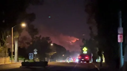 Palisades Fire, night with flames, from below San Vicente. 動画素材 297318948