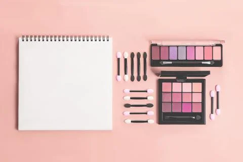 Pallet shadows and applicators with notepad on red background. Stock Photos