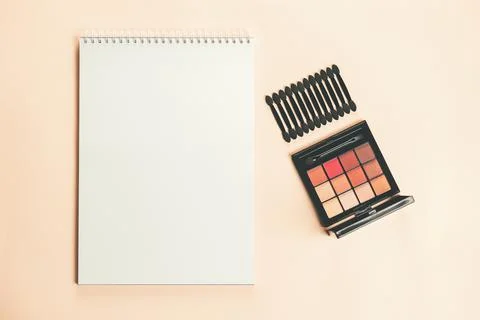 Pallet shadows and applicators with notepad on yellow background. Stock Photos