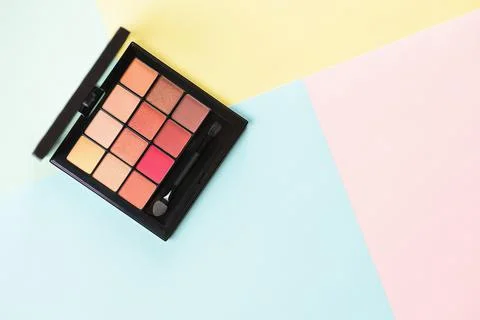 Pallet shadows for applying on face on multicolored background. Stock Photos