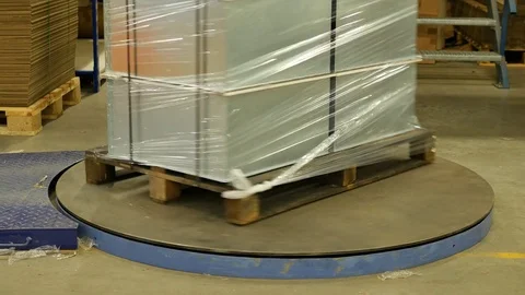 Pallet stretch wrapping machine wraps stainless steel products on a pallet Stock Footage 77591438