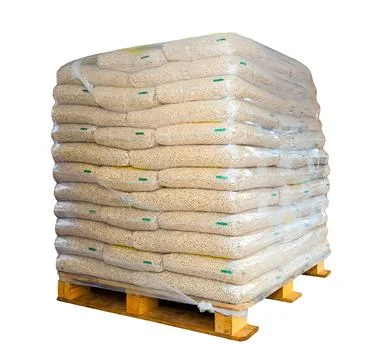 Pallets of wood pellets in plastic bags isolated on white background. Stock Photos