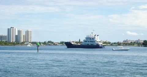 Palm Beach Florida Bay large Blue yacht against high rise buildings sunny day Stock Footage 213133272
