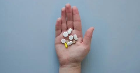 Palm with different pills on a blue background top view Stock Footage 235586653