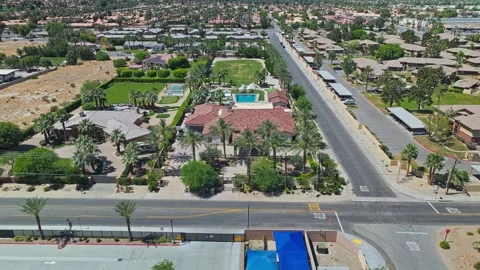 Palm Springs mansion, pullback to reveal city blocks with palm lined streets Video stock 334684232