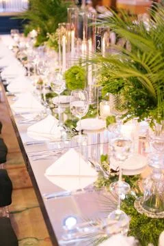 Palm tree leaf wedding table. Candles, napkins and mirrored tables. Stock Photos