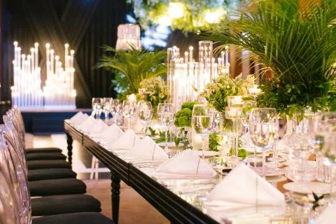Palm tree leaf wedding table. Candles, napkins and mirrored tables. Stock Photos