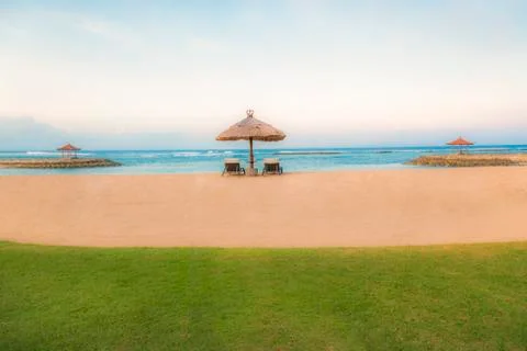 Palm trees on white sandy beach, two sunbed and parasol. View of nice tropica Foto stock