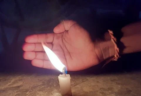 Palm using as guard wall for Candle Light flame from wind. Stock Photos