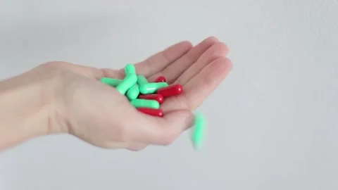 Palm on a white background, onto which pills are falling. Multi-colored pills Video stock 262422678
