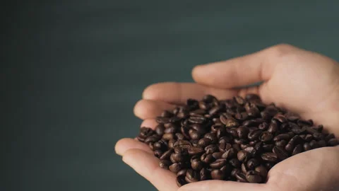 The palms hold a handful of coffee beans. Close-up of ready-to-drink coffee Stock Footage 268412704