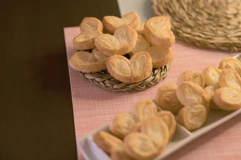 Palms of puff pastry on white rectangular plate and wicker plate Stock Photos