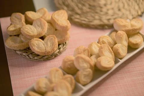 Palms of puff pastry on white rectangular plate and wicker plate Stock Photos