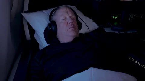 Pampered, older man in first class on a flight reclined and watching a movie Stock Footage 314879469