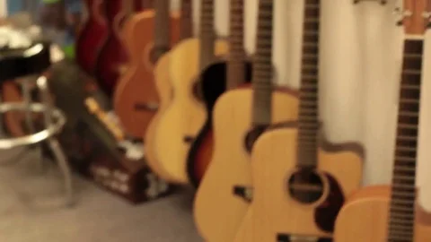 Pan to acoustic guitars on wall rack Stock Footage 69111217