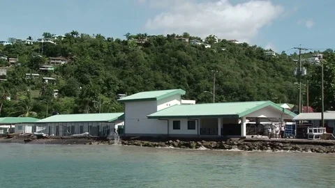 Pan across the beach in Anse la Raye with fishing boats moored Stock Footage 75218538