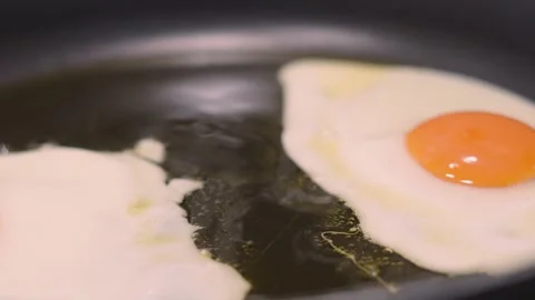 Pan Across Bubbling Fried Eggs in Pan with Olive Oil. Stock Footage 341375746
