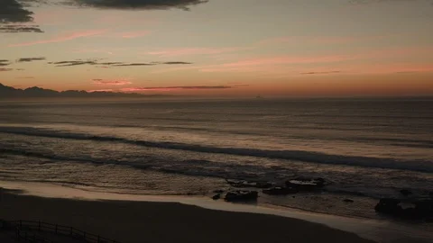 Pan across cloudy Hartenbos Beach with start of dusk / twilight on the horizon Stock Footage 124605277
