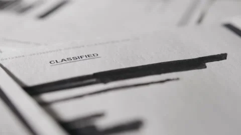 Pan across a document with classified written on top. Censored text and info Stock Footage